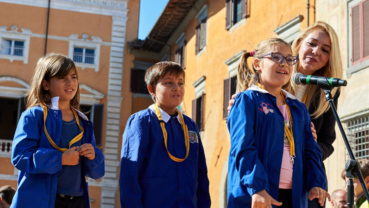 Ein Mädchen stellt Seiner Heiligkeit dem Dalai Lama eine Frage während des öffentlichen Vortrages auf dem Piazza dei Cavalieri in Pisa, Italien, am 20. September 2017. Foto: Olivier Adam