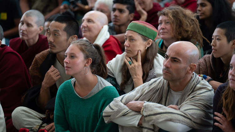 Touristen aus über 68 Ländern verfolgen die Rede von Seiner Heiligkeit dem Dalai Lama im Hof des tibetischen Haupttempel in Dharamsala, HP, Indien am 16. April 2018. Foto: Tenzin Choejor